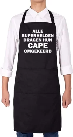 KARIBAN ALLE SUPERHELDEN DRAGEN HUN CAPE OMGEKEERD Herenschort - Zwart Met Witte Tekst - One Size (volwassenen) - Luxe Schort - Keuken | Barbeque | BBQ | Bedienings Schort - Grappige Teksten | Designs - Voor De Stoere Man - Verstelbaar - Cadeau